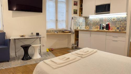 eine Küche mit einem Bett und einem Tisch in einem Zimmer in der Unterkunft Le studio d'Agathe centre historique - Confort & Calme in Valence
