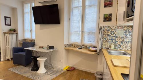une petite cuisine avec un évier et une table dans l'établissement Le studio d'Agathe centre historique - Confort & Calme, à Valence