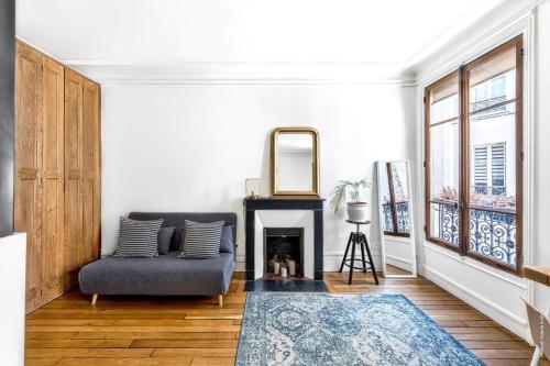 un salon avec un canapé et une cheminée dans l'établissement Gros Caillou - Bourdonnais 1bdr, à Paris