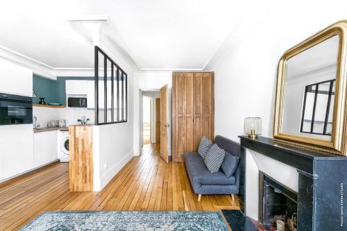 un salon avec une cheminée et une chaise bleue dans l'établissement Gros Caillou - Bourdonnais 1bdr, à Paris