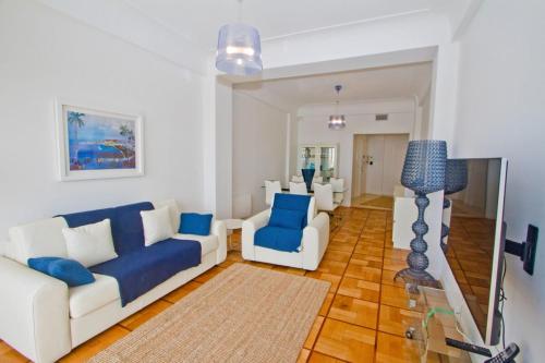 a living room with a white couch and blue chairs at Promenade des Anglais - Sea View 2bdr in Nice