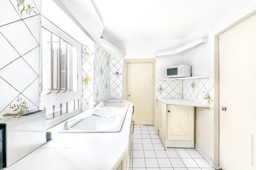 La salle de bains est pourvue d'une baignoire et d'une fenêtre. dans l'établissement Ile Saint Louis - Quai d'Orleans 2bdr, à Paris
