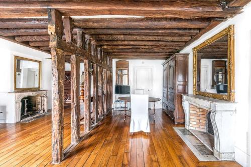 un salon avec une table et une cheminée dans l'établissement Ile Saint Louis - Quai d'Orleans 2bdr by B'Your Home, à Paris