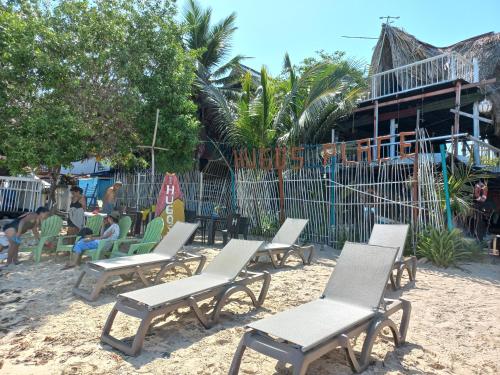 un gruppo di sedie sedute sulla sabbia della spiaggia di Hugos Place Baru a Cartagena de Indias