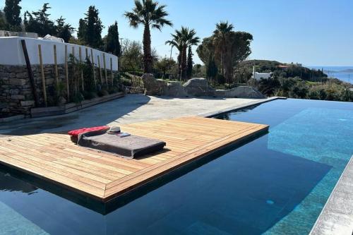 a swimming pool with a wooden deck on the water at Villa Mahé Tennis Karystos island EVIA in Karistos
