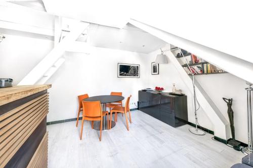 une cuisine et une salle à manger avec une table et des chaises dans l'établissement Montparnasse - La Gaïté 1bdr - B'Your Home, à Paris