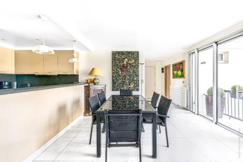 une cuisine et une salle à manger avec une table et des chaises dans l'établissement Maillot Ternes - Saint Ferdinand 3bdr, à Paris