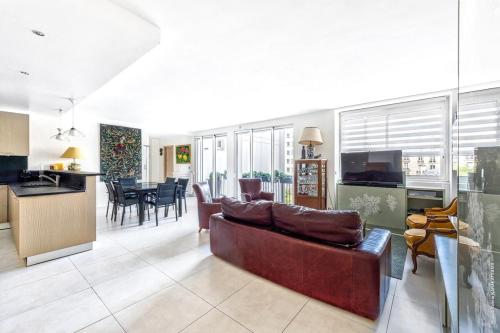 Il comprend un grand salon avec un canapé et une cuisine. dans l'établissement Maillot Ternes - Saint Ferdinand 3bdr, à Paris