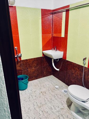 a bathroom with a toilet and a sink at Puthookadans Mareena Lodge in Kottayam