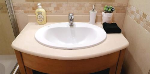 a white sink in a bathroom with a soap dispenser at Encosta Da Orada in Albufeira