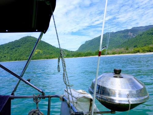 a boat on the water with mountains in the background at Paseos en Velero en Angra dos Reis in Angra dos Reis