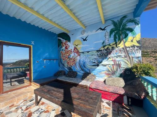 a room with a couch and a mural on the wall at Boilers Surf House in Tamri