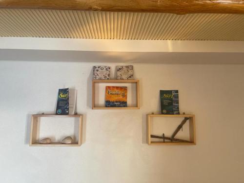 a wall with three wooden shelves on a wall at Boilers Surf House in Tamri