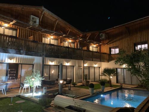 ボルドーにあるLa Cabane D'Ambroiseの夜間のスイミングプール付きの建物