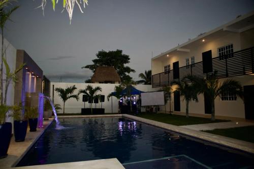 a swimming pool in front of a building at night at OTOCH HE'ELEL in Huay Pix