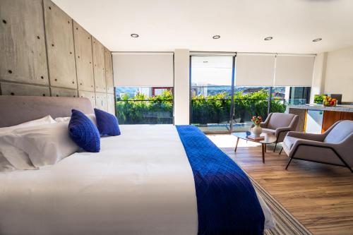 a bedroom with a large white bed with blue pillows at KUKO SUITES in Chilpancingo de los Bravos