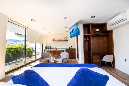 Chilpancingo de los BravosにあるKUKO SUITESの青い枕が付いた大きなベッドのある寝室