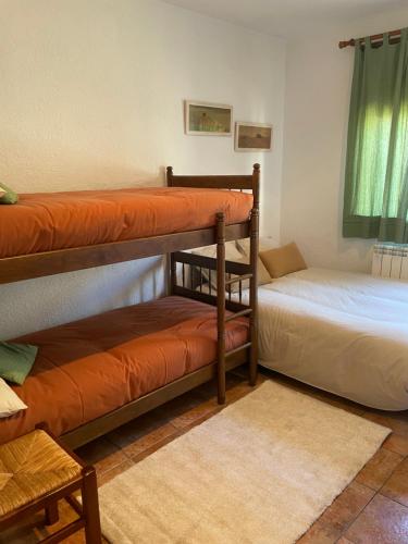 een kamer met 2 stapelbedden en een bank bij Cal mosso in Collsuspina