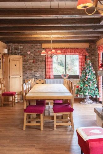 une salle à manger avec une table et un sapin de Noël dans l'établissement Chalet des 3 Vallées, spacious and comfortable 12p, à La Bresse