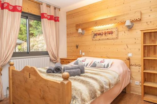 une chambre avec un grand lit dans une pièce aux murs en bois dans l'établissement Chalet des 3 Vallées, spacious and comfortable 12p, à La Bresse