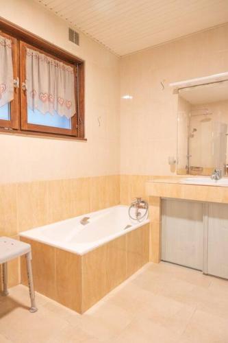 une salle de bain avec une baignoire et un lavabo dans l'établissement Chalet des 3 Vallées, spacious and comfortable 12p, à La Bresse