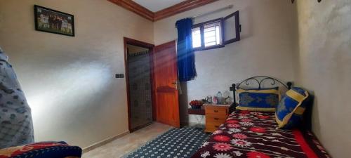 een kleine slaapkamer met een bed en een raam bij Dar Salam in Dakhla