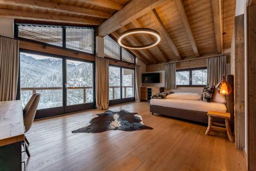 a bedroom with a bed and large windows with mountains at Chalet VIE in Viehhofen