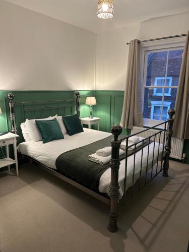 um quarto com uma cama com paredes verdes e uma janela em Waverley Inn em Newport