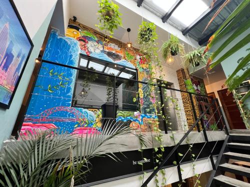 un mural colorido al lado de un edificio con plantas en Canova en Panamá
