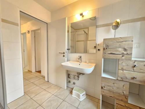 a bathroom with a sink and a mirror at Mienhus Apartments Ferienwohnung Jantje in Norden