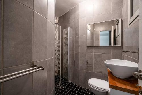 a bathroom with a sink and a toilet and a mirror at Penthouse Mapu - Mamad in Tel Aviv