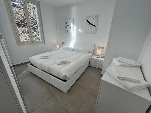 a white bedroom with a large bed and a window at My Residence d'Azur Maison Micheloni in Beausoleil