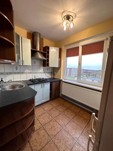 een keuken met een wastafel en een raam bij Redroomas in Kėdainiai