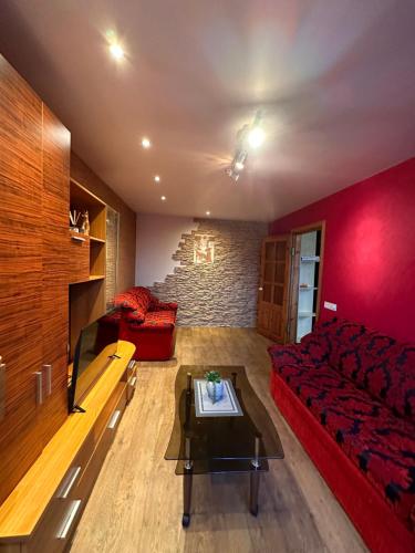 een woonkamer met een rode bank en een tafel bij Redroomas in Kėdainiai