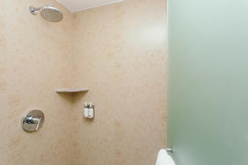 a bathroom with a shower with a toilet and a door at Mareazul Beach Front Condos At playa del Carmen in Playa del Carmen