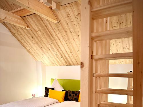 una camera con letto a soppalco e soffitto in legno di Das Rizzi 