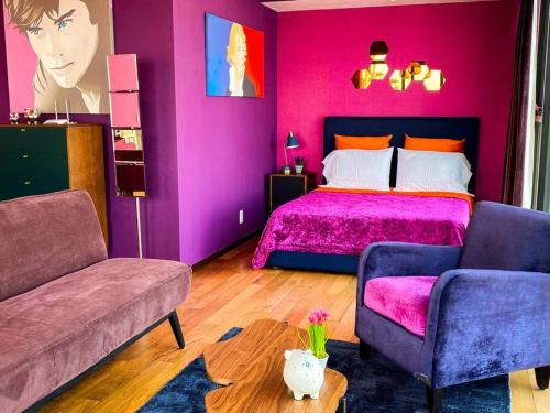 a purple bedroom with a bed and a couch at Suite Chic HCondesa in Mexico City