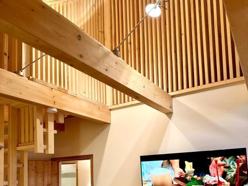 a living room with wooden stairs and a tv at Das Rizzi in Grössing