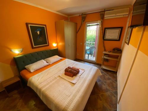una camera da letto con un grande letto con pareti arancioni di Markovic Apartmani Becici a Bečići