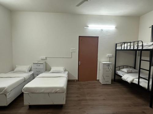 プネにあるElite Stays Viman nagarの二段ベッド3組とドアが備わる客室です。