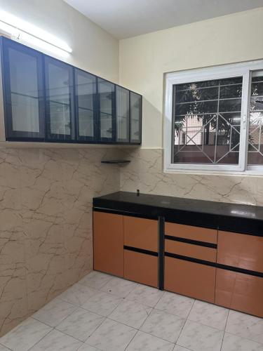 a kitchen with a counter and a window at Elite Stays Viman nagar in Pune