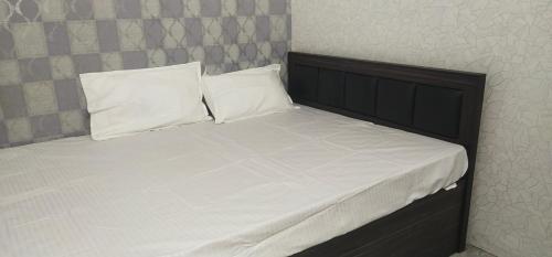 kolkataにあるHOTEL BLUE MOONのベッド1台(白いシーツ、枕2つ付)