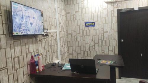 a room with a desk with a laptop and a tv at HOTEL BLUE MOON in kolkata