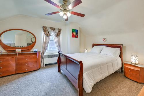 a bedroom with a bed with a ceiling fan and a mirror at Mount Vernon Getaway - 4 Mi to the Bronx Zoo! in New Rochelle