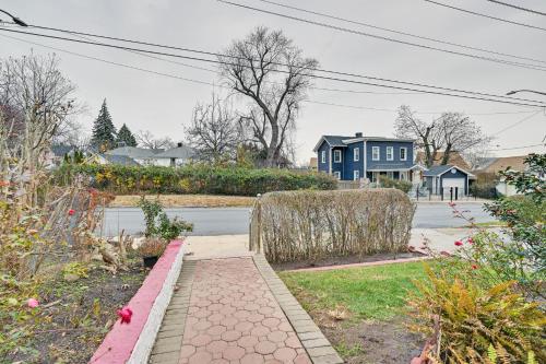 a residential street with a blue house in the background at Mount Vernon Getaway - 4 Mi to the Bronx Zoo! in New Rochelle