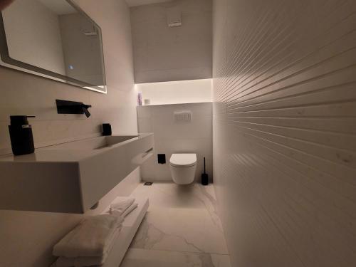 une salle de bain blanche avec toilettes et lavabo dans l'établissement La Mirage Suites & Apartments, à Tirana
