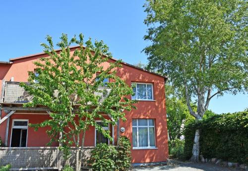 ティースゾーにあるAppartementhaus auf Moenchgutの木の前の赤い家