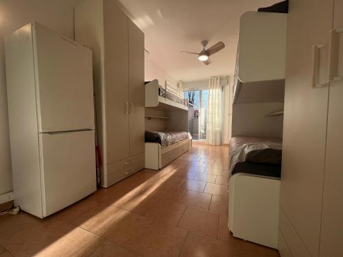 a small room with two beds and a refrigerator at Einaudi Sweet Home - Cologno Monzese in Cologno Monzese