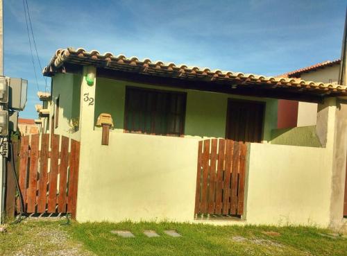 una pequeña casa con una valla de madera delante de ella en residencia bem viver, en Arraial do Cabo