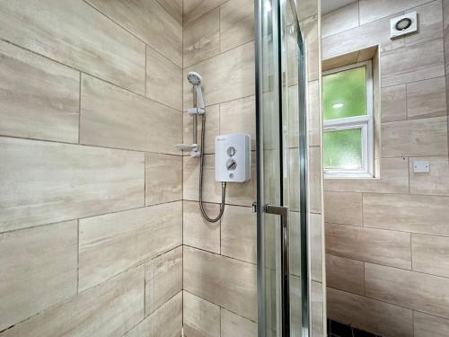 La salle de bains est pourvue d'une douche avec une porte en verre. dans l'établissement Bright and Airy Studio in Trendy Birmingham Locale, à Birmingham